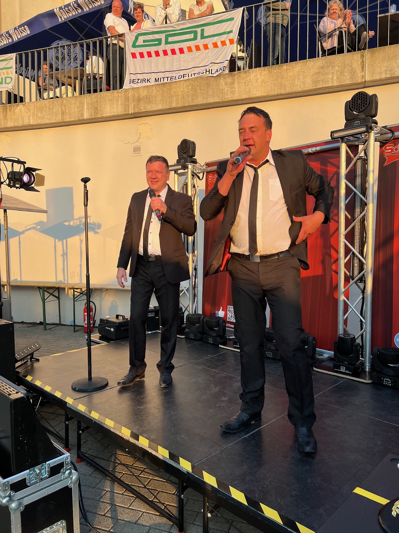 Schichtwechsel – Sängerduo im Anzug bei Sonnenlicht